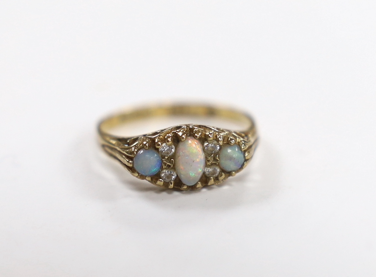A 9ct gold and three stone white opal set ring, with CZ spacers, size L, gross weight 1.6 grams.